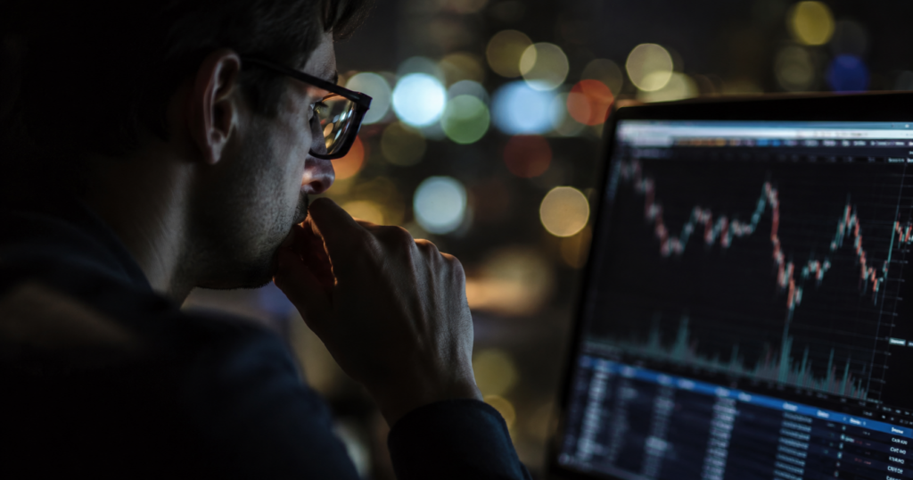 person looking at computer monitor showing line graph